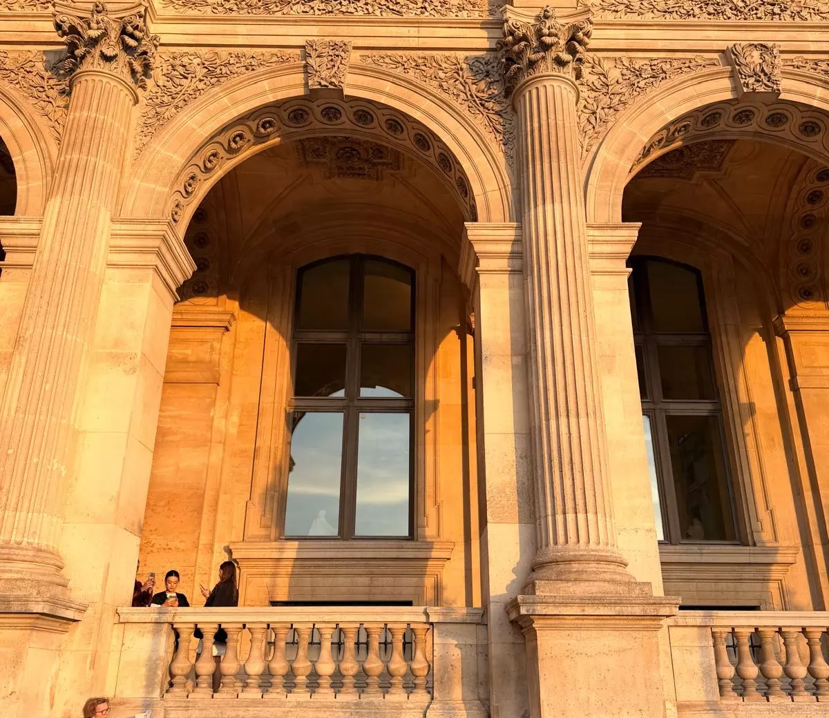 Arcades et colonnes d’un palais parisien au soleil couchant